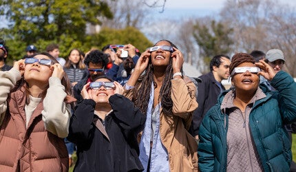 Yale community members viewing the solar eclipse through special glasses
