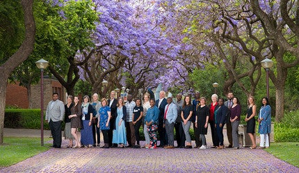 Conference participants pose amid Jacaranda trees, iconic for Pretoria which is known as the Jacaranda City.