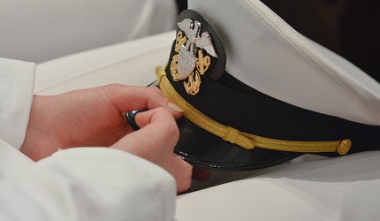 A Yale NROTC officer holds hat in hands.