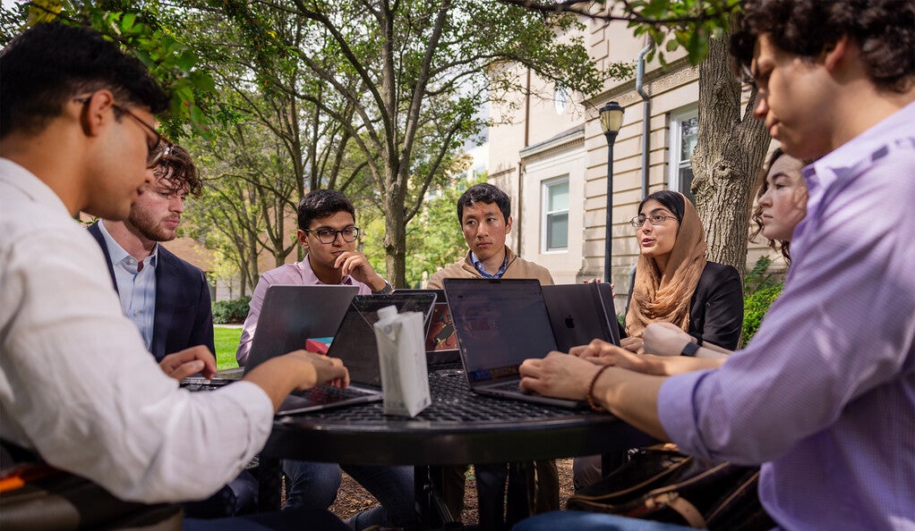 Development Economics Club members meeting at a table outside.