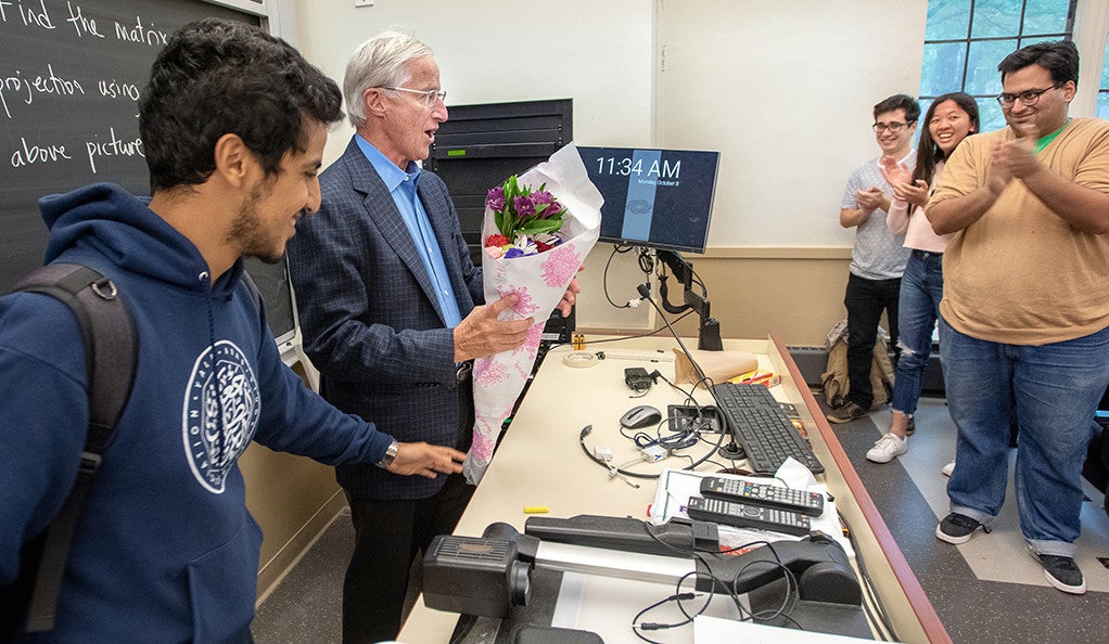 William Nordhaus receives flowers from students on the day of his Nobel Prize announcement.