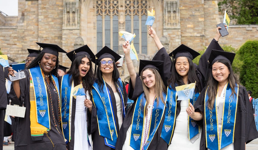 Branford College graduates in front of Sterling Memorial Library