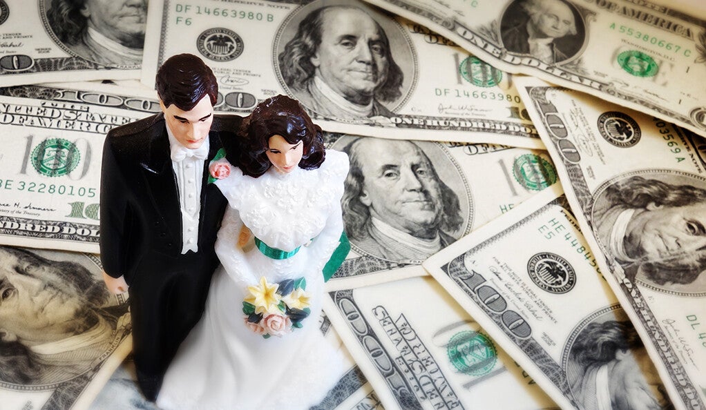 Married couple figurines, on a pile of money. 