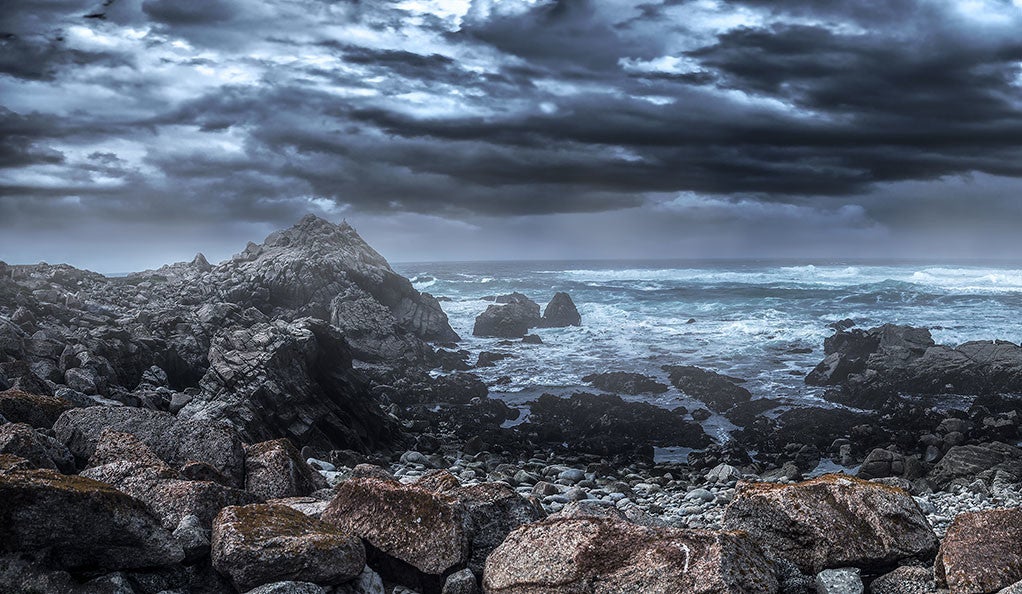 A stormy California beach, with ominous clouds and crashing waves.