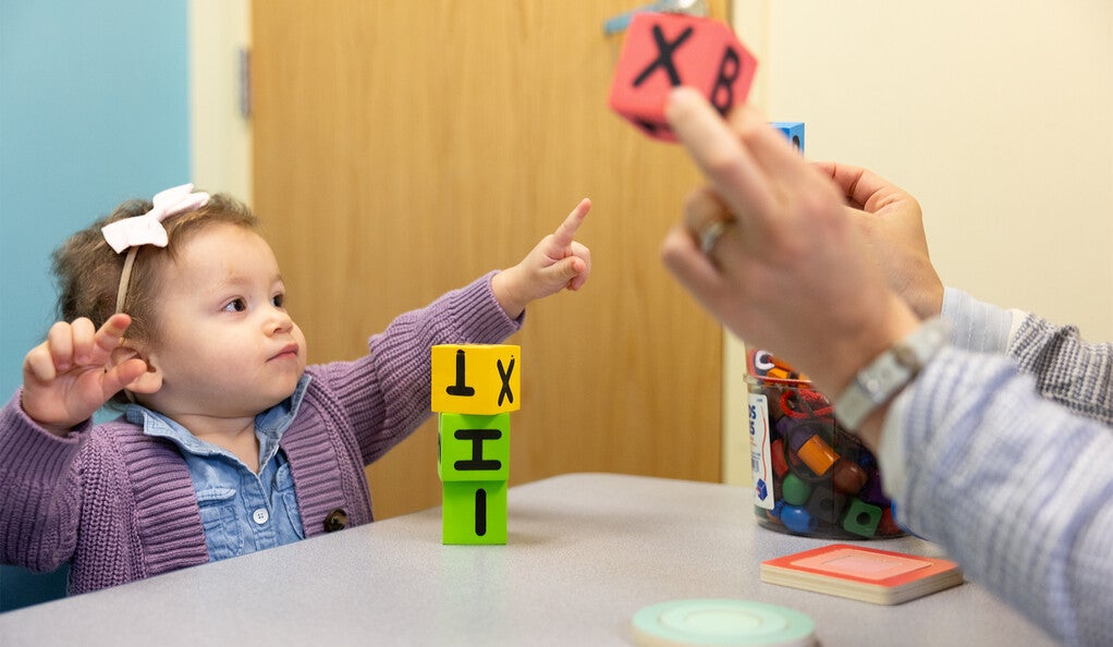 A child pointing at a colorful block