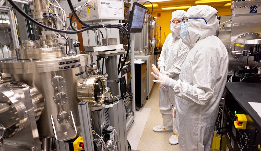Researchers wearing clean suits in a lab
