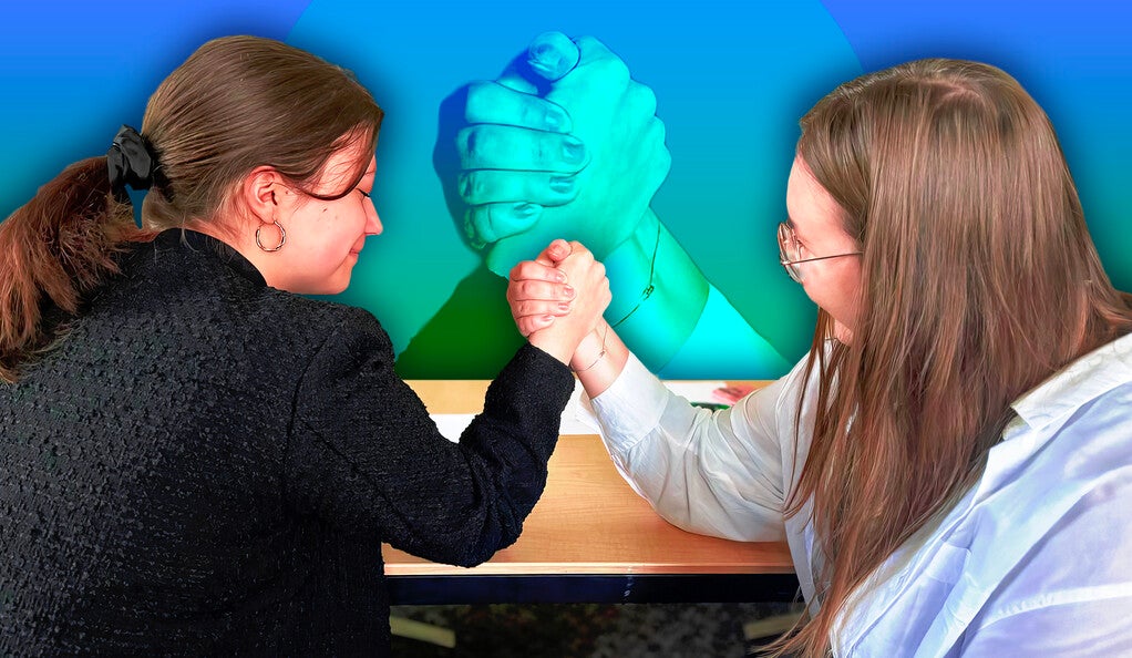 Veronika Makoviak and Anastasiia Pohoretska engage in an arm-wrestling contest