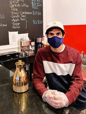 A man wearing a mask in a coffee shop.