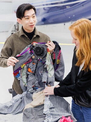 Wai Hin Wong and Dana Karwas, one of the course’s instructors, prepare the flight suit for the zero gravity test flight.