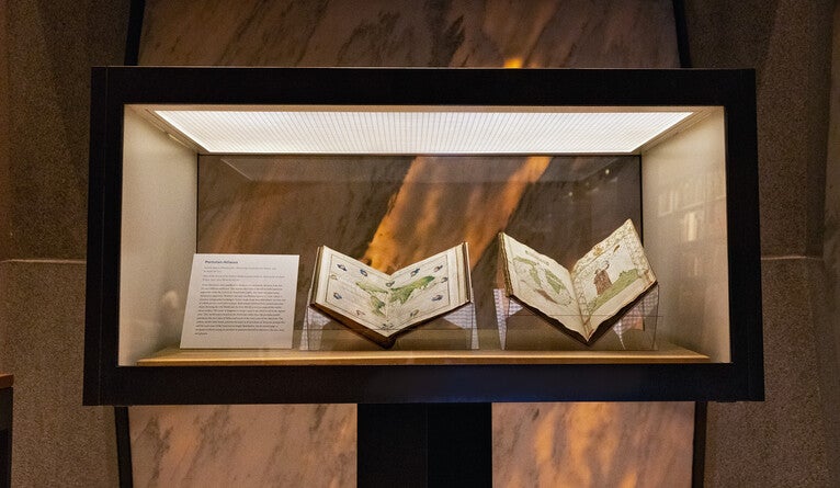 Books of maps inside a display case