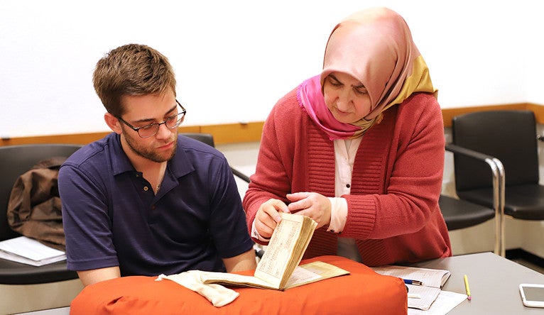 Matthew Dudley, left, and Ozgen Felek study an Ottoman Turkish account book during a class at the Beinecke Library.