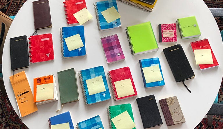 A collection of tiny notebooks and pocket diaries from the 1990s and the 2000s. Post-its indicate the year Koestenbaum used 