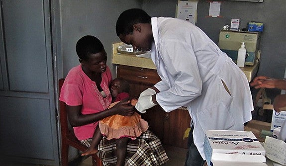 Ssenyange performing a malaria Rapid diagnostic test on a patient at Pajule Health Centre in Northern Uganda