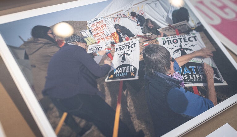 Activists hand color placards outside the “Art Tent” at the Oceti Sakowin camp during the 2016 Dakota Pipeline protests.