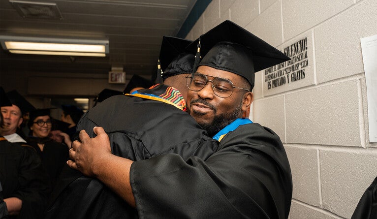 Graduates Maurice Blackwell and Marcus Harvin embrace during the June 9 ceremony.