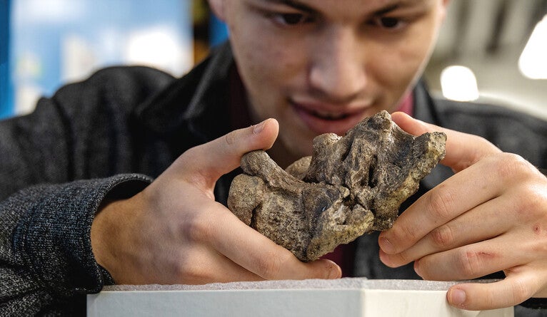 Chase Brownstein examines a fossil